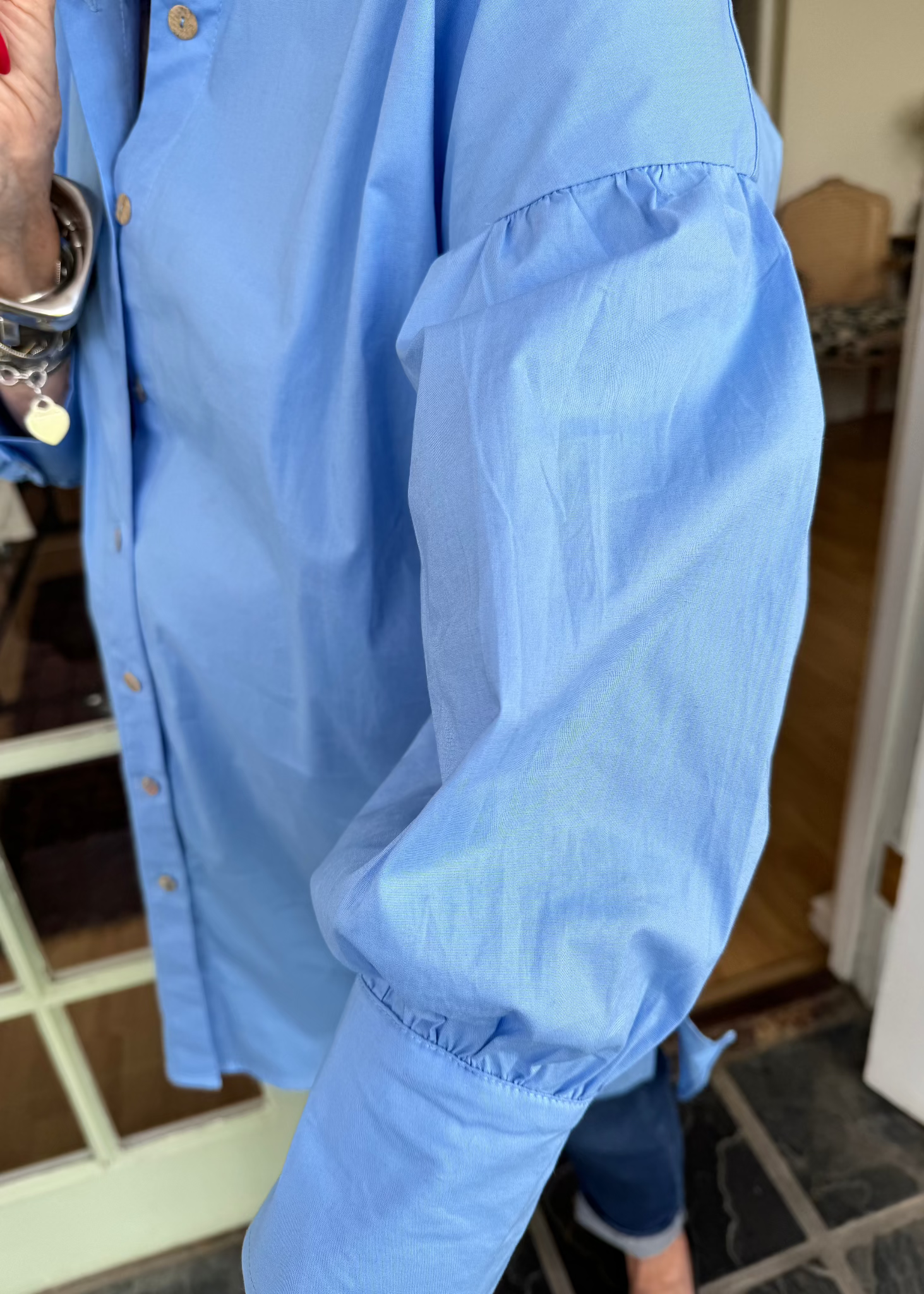 Jenny le Roux wearing a blue 100% cotton shirt, with a hint of a puff sleeve.