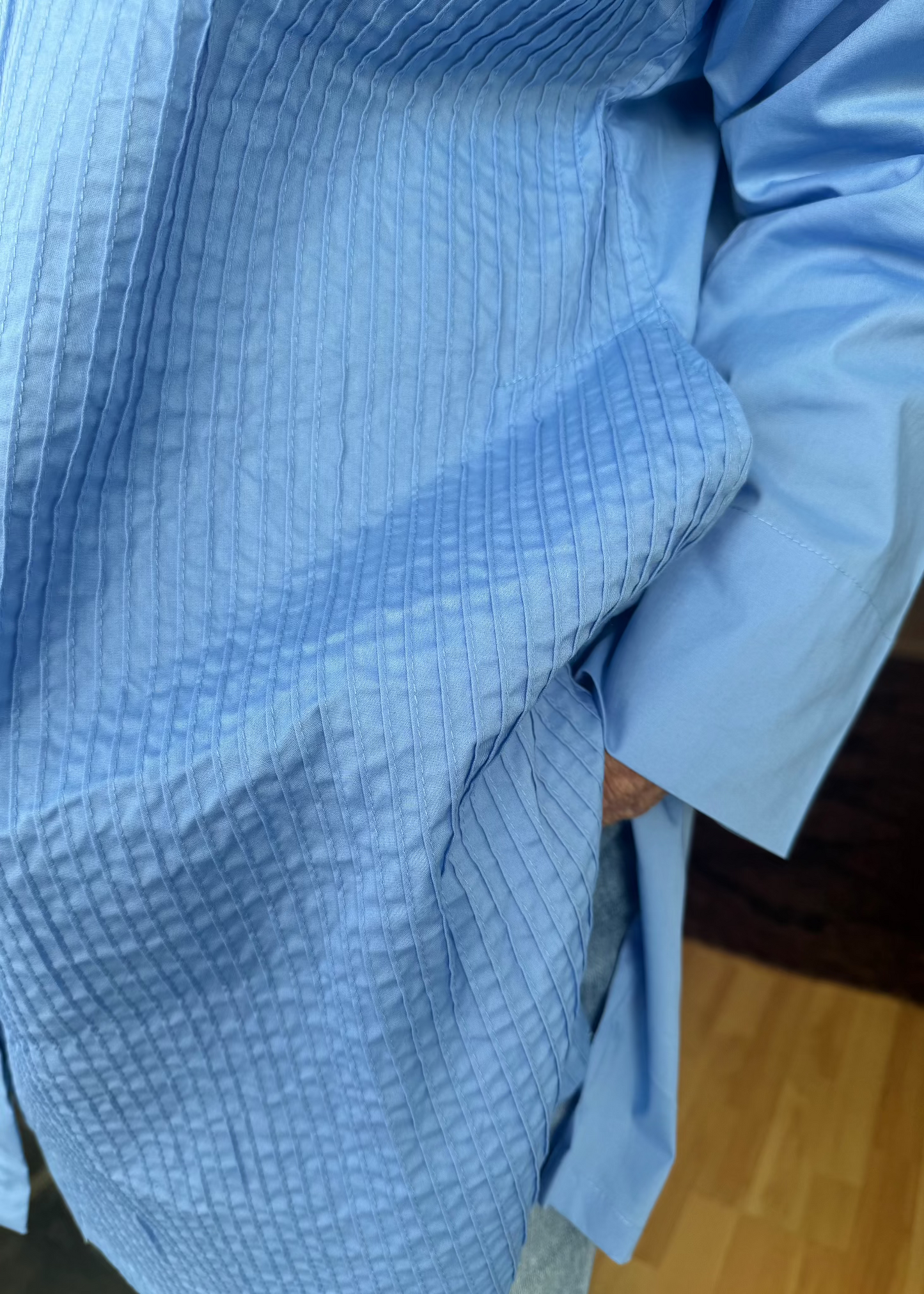 Crafted from crisp cotton with intricate pleating at the front and a sleek plain back, this exceptionally designed shirt offers the perfect balance of structure and flow. The elongated silhouette gracefully skims the body, providing an effortlessly slimming effect, while its generous length allows it to double as a lightweight jacket when left unbuttoned.