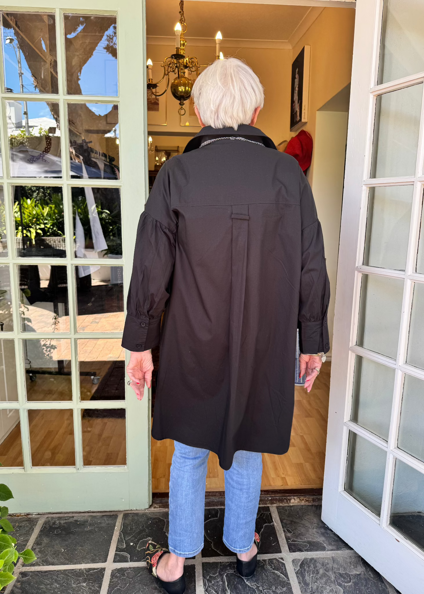 Jenny le Roux wearing a crisp black 100% cotton shirt, with a hint of a puff sleeve.