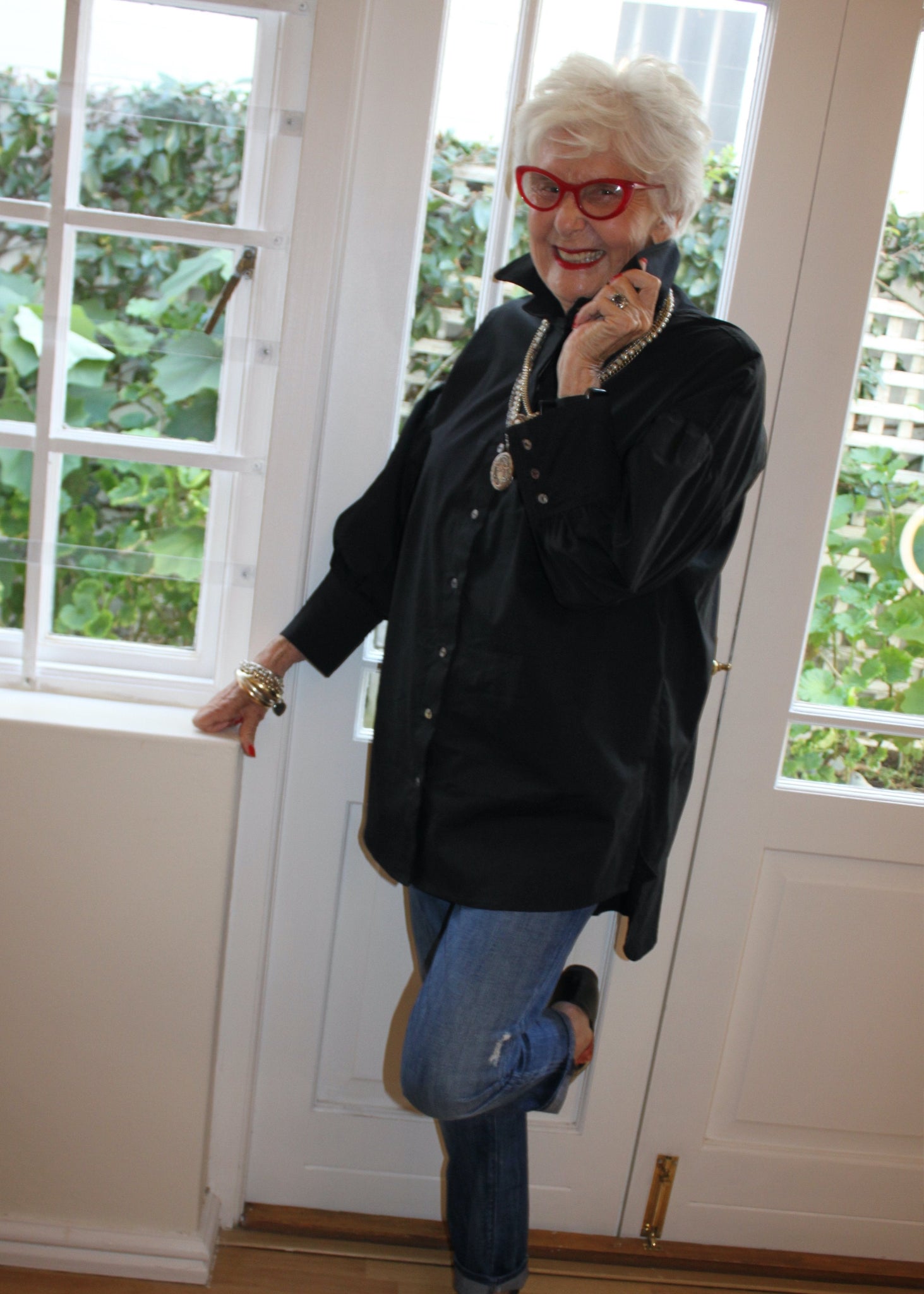 Jenny le Roux wearing a black 100% cotton shirt, with a hint of a puff sleeve.