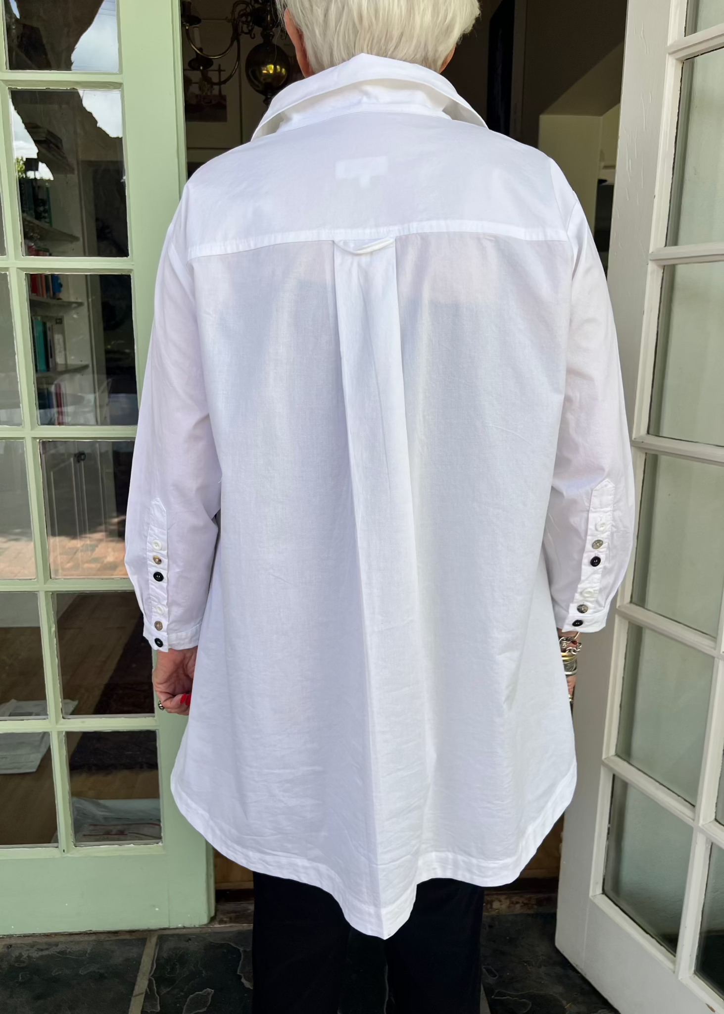 With its cheerful lineup of 26 buttons in three contrasting colours, this crisp cotton shirt brings a touch of whimsy to your everyday wardrobe. Designed with thoughtful asymmetry, it sits slightly shorter at the front and longer at the back - a clever detail that makes it the perfect partner for our Wide-Legged Pants.