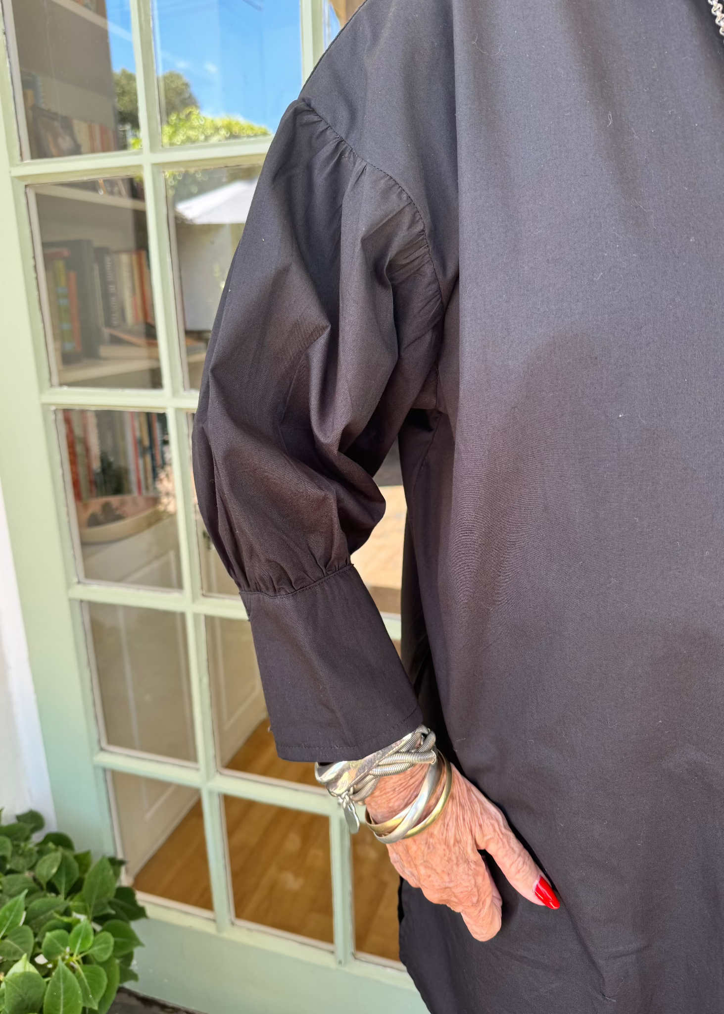 Jenny le Roux wearing a crisp black 100% cotton shirt, with a hint of a puff sleeve.